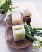 Square candles and flower bulbs on a wooden tray