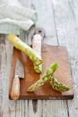 Green asparagus, sliced, on a chopping board