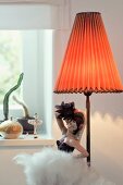 China doll of dancer next to lamp with lampshade