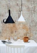 Old kitchen funnels used as unusual lampshades above breakfast table