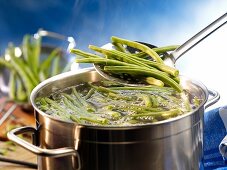 Green beans being added to a pot of boiling water