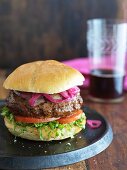 Cheeseburger mit Cheddar, Zwiebeln, Salat und Tomaten