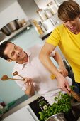 Zwei Freunde beim gemeinsamen Kochen in der Küche