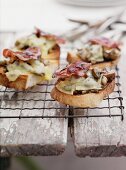 Gratinated toast slices with mushrooms, cheese and bacon