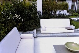 Corner seating with white sofas and table in the garden