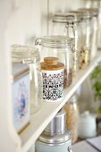 Various foods in storage jars on a kitchen shelf