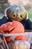 Person wearing a hollow pumpkin on their head