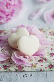 Heart-shaped vanilla macaroons on peony petals