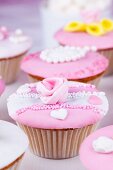 Cupcakes with pink and white glaze and sugar roses