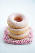 Doughnuts with pink sugar icing on a crocheted coaster