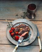 Entrecote with grilled cherry tomatoes on a tin plate