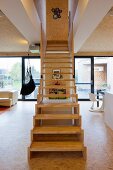 Modern, wooden staircase in open-plan interior