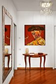 Mixture of styles in hallway - Spanish painting, elegant console table, full-length mirror and designer lamp
