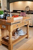 Tomatoes and vinegar jug on chopping block with solid wooden frame in front of vintage cooker in niche