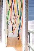 Children's birthday party - view through an open door of a colorful streamers hanging from the ceiling and birthday garland