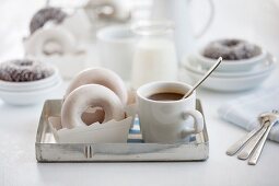 Doughnuts und eine Tasse Kaffee auf einem Tablett