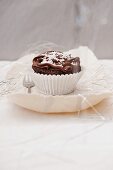 A chocolate cupcake decorated with white beads