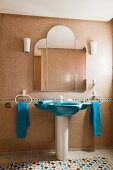 Blaues Standwaschbecken und dreiteiliger Spiegel an Wand in modernem Bad