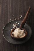 Round grain rice in a rustic wooden ladle