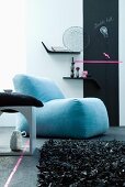 Zeitgenössische Sitzecke mit blauem Polstersessel und Leder-Fransenteppich vor minimalistischen Wandboards und Tafelstreifen