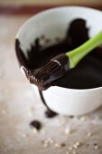 Liquid chocolate in a bowl and on a brush