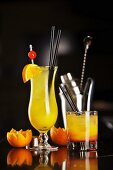 Zwei Cocktails mit Orangensaft, Gin und Campari