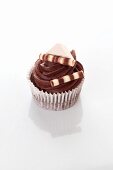 A chocolate cupcake decorated with chocolate sticks