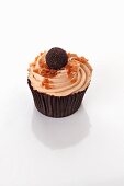 A cupcake decorated with a chocolate praline