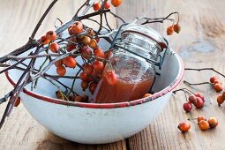 Hawthorn jelly and hawthorn twigs in an enamel bowl
