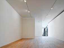 Leerer Galerieraum mit Lichtstrahlern an Decke und Parkettboden (Photographers' Gallery, London)