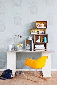 Old wooden crates used as shelves on desk and Charles Eames rocking chair