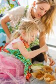 Woman and Young Girl Frosting Cupcakes