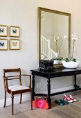 Antique furniture and old typewriter in front of mirror in hallway