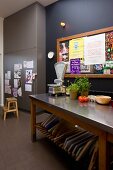 Kitchen table with a stainless steel top in front of a black wall