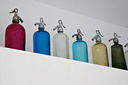 Collection of vintage soda bottles on a brick shelf