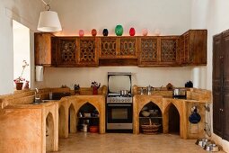 Indische Küche - Gemauerte Küchenzeile mit spitzbogenartigen Öffnungen in Unterschränken und geschnitzte Hängeschränke