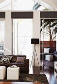 Living room with leather sofa and stained parquet floor; seating area on terrace below palm trees