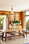 Rustic wooden table and wire-framed chairs on pale, glossy tiled floor in traditional setting