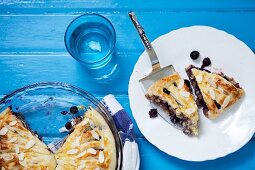 Two Slices of Blueberry Pie on a Plate with Pie Server; Pie in Baking Dish; From Above