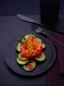 Salmon tartar on a bed of cucumber with mango chutney
