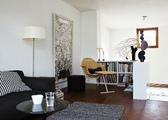 Upholstered sofa and small reading corner with half-height bookcase and Delta armchair in living room