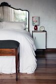 Mirrored headboard with curved wooden frame on bed in bedroom