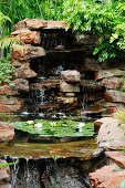 Cascades and flowering waterlilies in pond