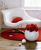 Sitting room detail with distressed walls, and a white moulded plastic chair on a round, red rug.