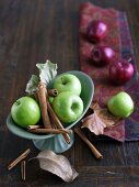 Granny Smith Apples with Cinnamon Sticks; Red Apples in Background
