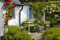 Small table and chairs in front of white-painted house