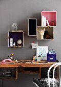 Various boxes with painted inner surfaces used as creative storage space in office