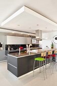 Gray, kitchen counter with colorful, upholstered bar stools in an open kitchen
