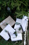 Schlichte Geschenkpäckchen mit schwedischem Weihnachtsgruss unter Tannenbaum im Freien
