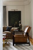 Elegant, art-deco-style armchair and partially visible couch on rug with three-dimensional pattern in corner of grand living room